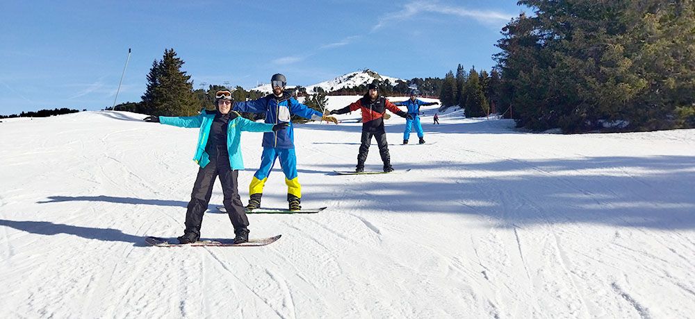 cours de snowboard adulte, au soleil, avec le sourire